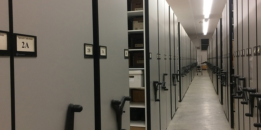 An aisle flanked by rows of moveable storage shelves.