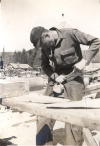 A CCC worker near Acadia National Park using a tool at a workbench.