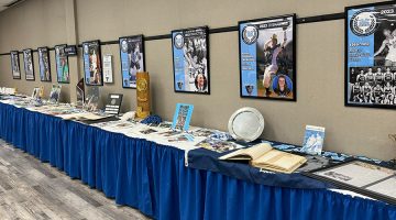 Posters and objects from university collections on display tables